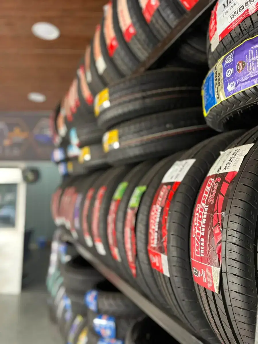 Rows of new car tyres stacked on racks at Yamoto tyre shop, Narsingi